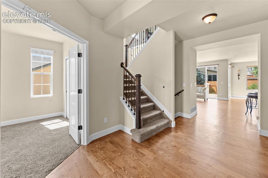 Image 7 of 50: entry with view of office/flex bedroom on the main, stairs and entry to liv