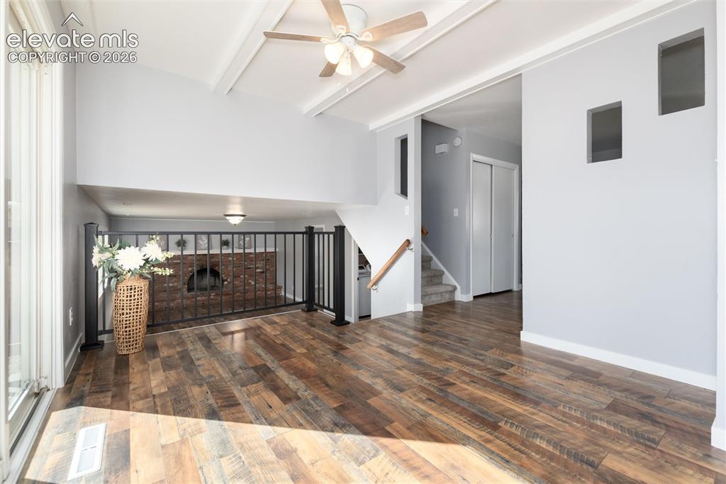 Image 12 of 47: Vaulted ceiling with exposed beams, wood-finish flooring, ceiling fan, and 