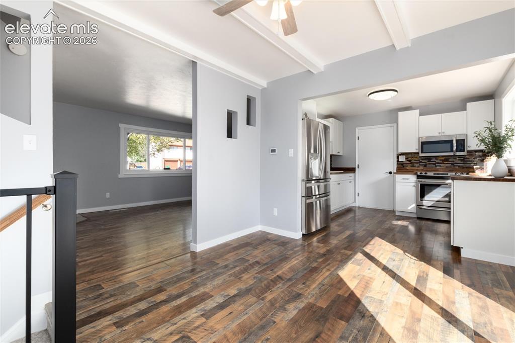 Image 13 of 47: Wood-finish flooring throughout, white upper and lower cabinetry, stainless