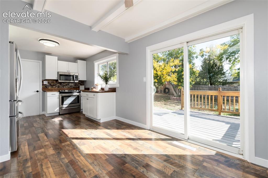 Image 14 of 47: Kitchen featuring white cabinetry, stainless steel appliances, wood-finish 