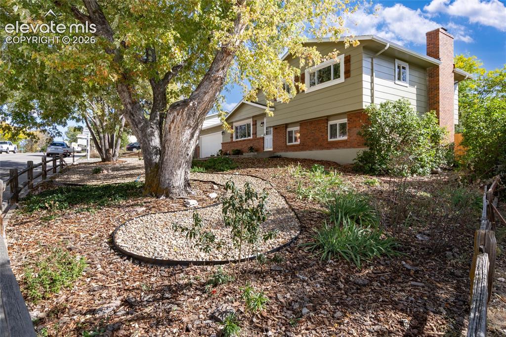 Image 2 of 47: Split-level exterior with brick and siding facade, integrated chimney, and 