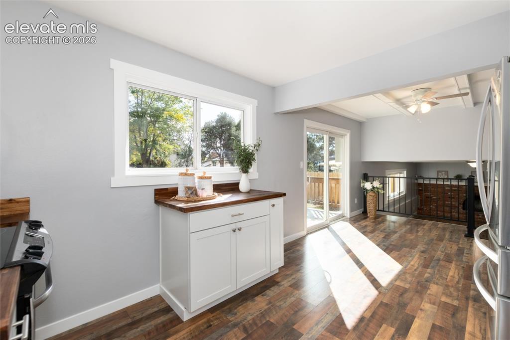 Image 21 of 47: Kitchen featuring wood-finish flooring, white cabinetry, a wood-finish coun