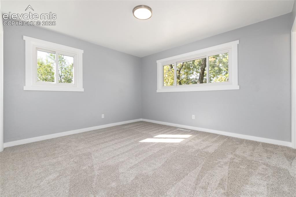 Image 27 of 47: Plush carpeting, light gray wall finish, and white trim windows