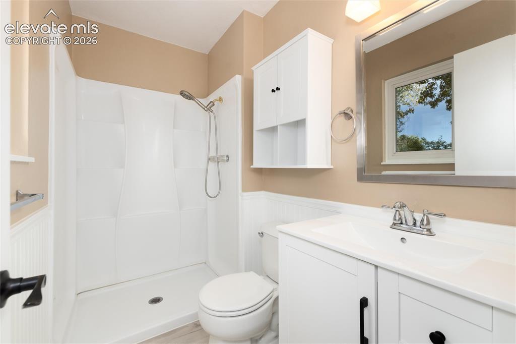 Image 28 of 47: White vanity with integrated sink, chrome faucet, wall-mounted mirror, and