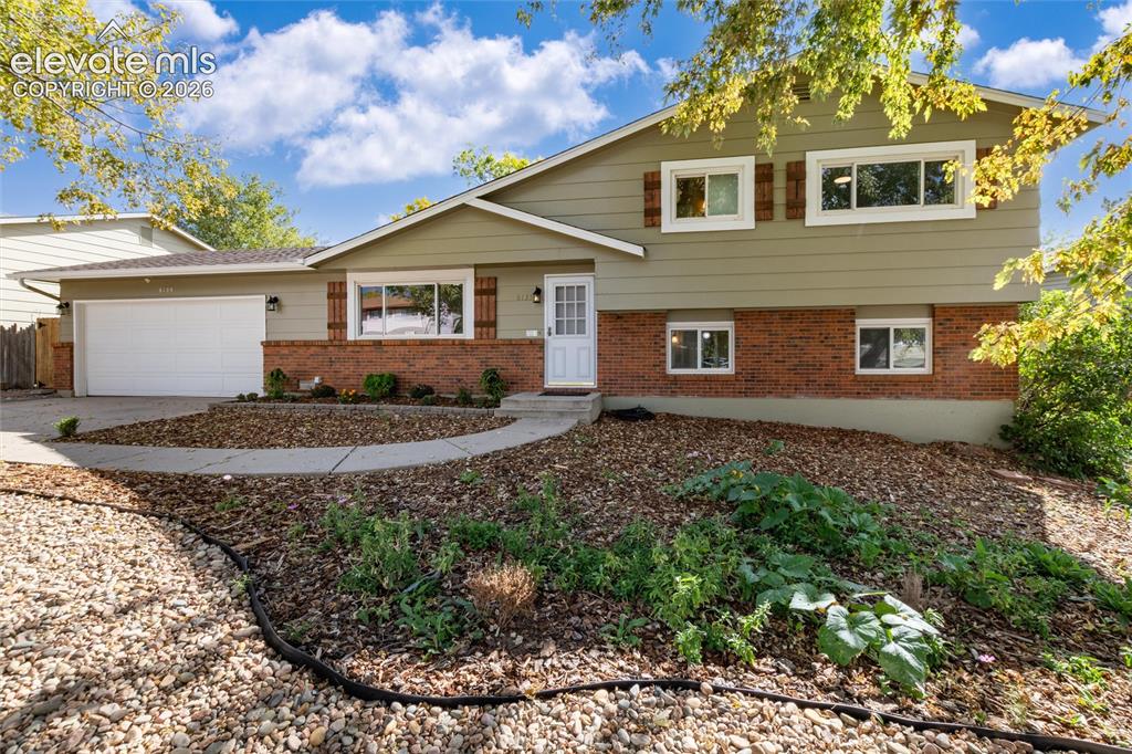 Image 3 of 47: Split-level residence featuring a two-car garage, brick and siding exterior