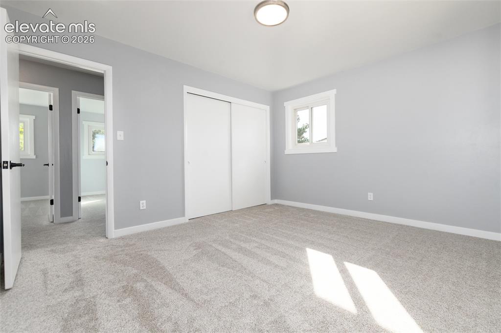 Image 30 of 47: Room with light gray wall paint, light-colored carpet flooring, white trim,