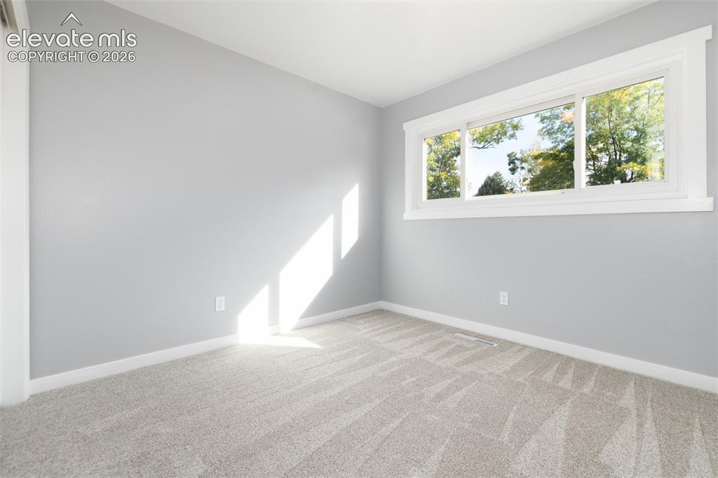 Image 32 of 47: Light gray wall paint, white trim, and a large window with natural light