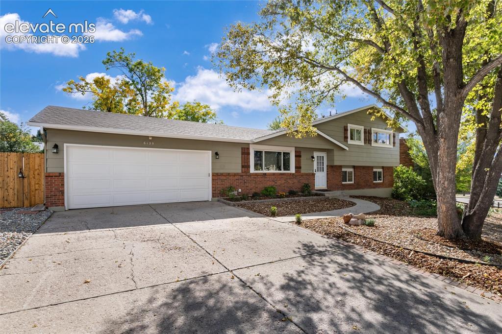 Image 4 of 47: Split-level residence featuring a two-car garage, brick and siding exterior