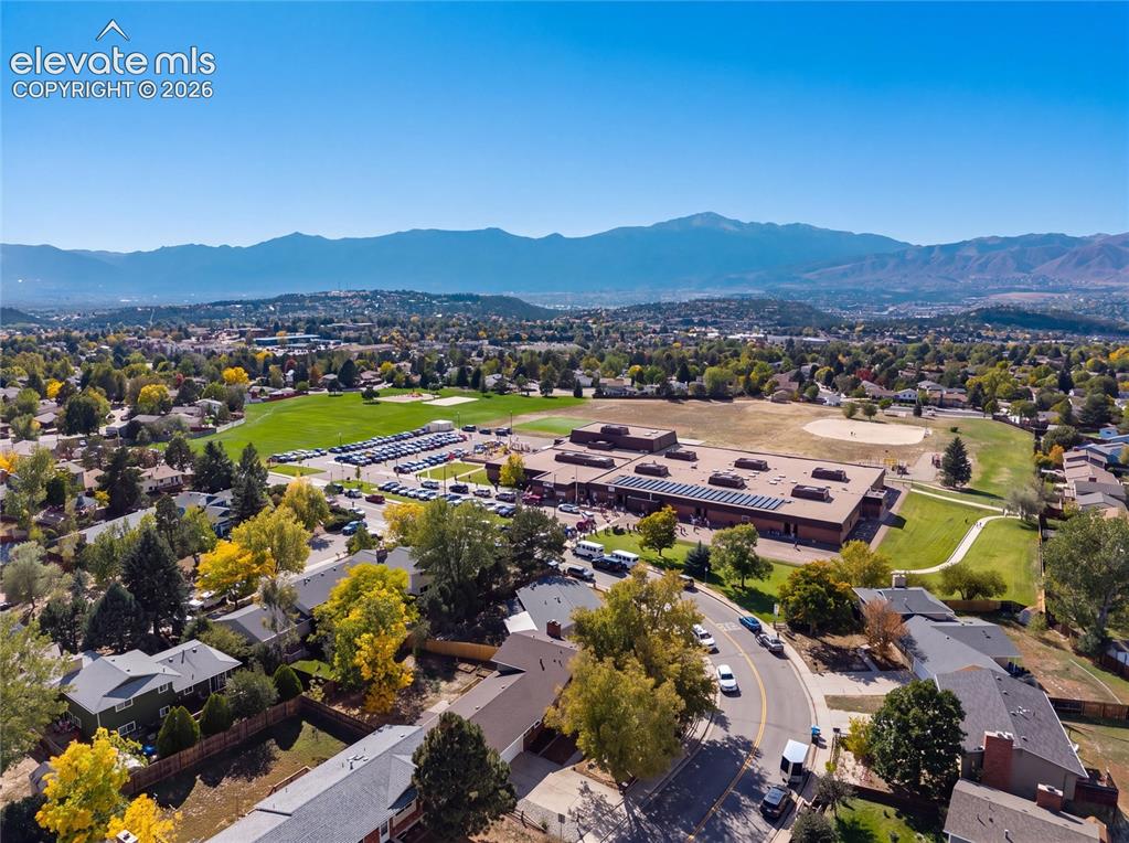 Image 42 of 47: Expansive community with mountain backdrop, residential area, and a large b