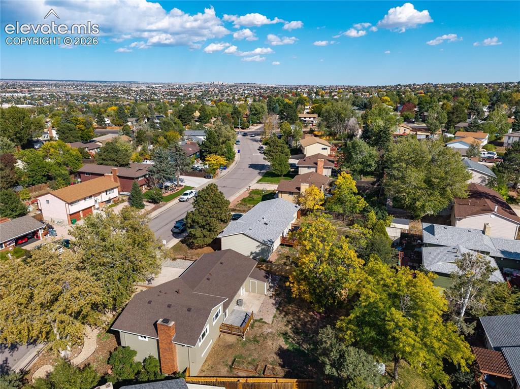 Image 47 of 47: Aerial perspective showcasing a residential street, dense tree canopy, and 