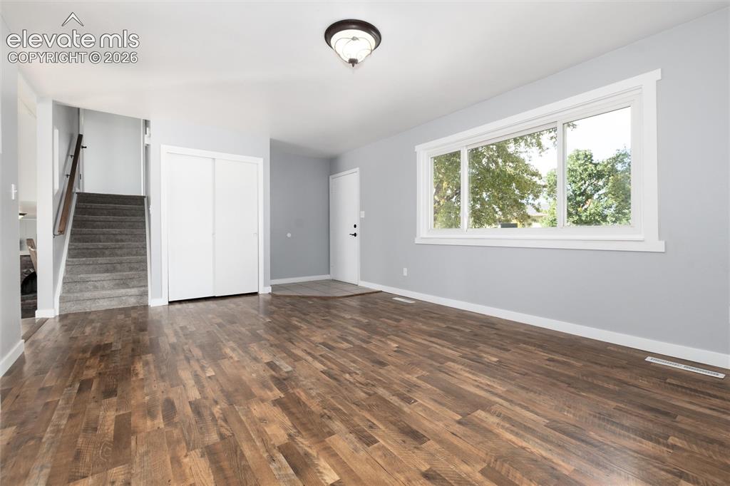 Image 6 of 47: Wood-finish flooring, white trim, recessed staircase, flush-mount ceiling l