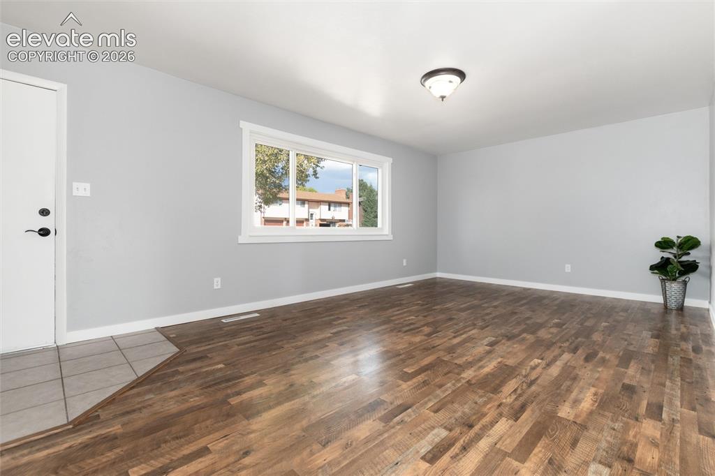 Image 7 of 47: Hardwood-finish flooring, light grey wall paint, and a white trim window
