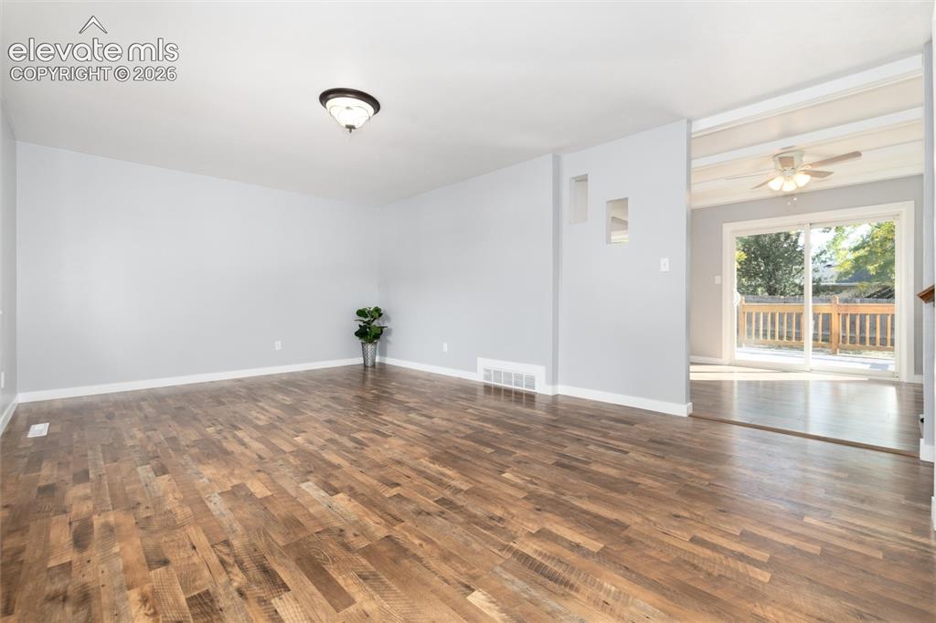 Image 8 of 47: Wood-finish flooring throughout, light-toned walls, and a semi-flush mount 