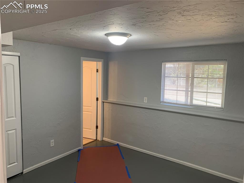 Image 19 of 32: Rec room with a textured wall and a textured ceiling