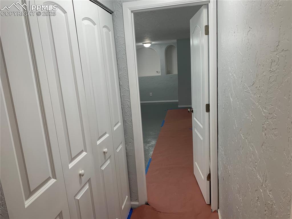 Image 20 of 32: Corridor with a textured wall and arched walkways