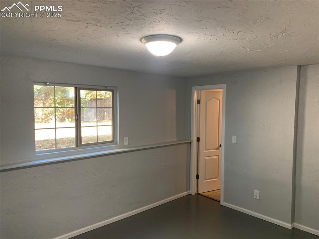 Image 25 of 32: Spare room featuring a textured ceiling and a textured wall