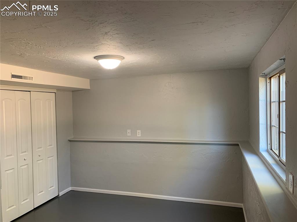 Image 26 of 32: Unfurnished bedroom with a textured ceiling and a closet
