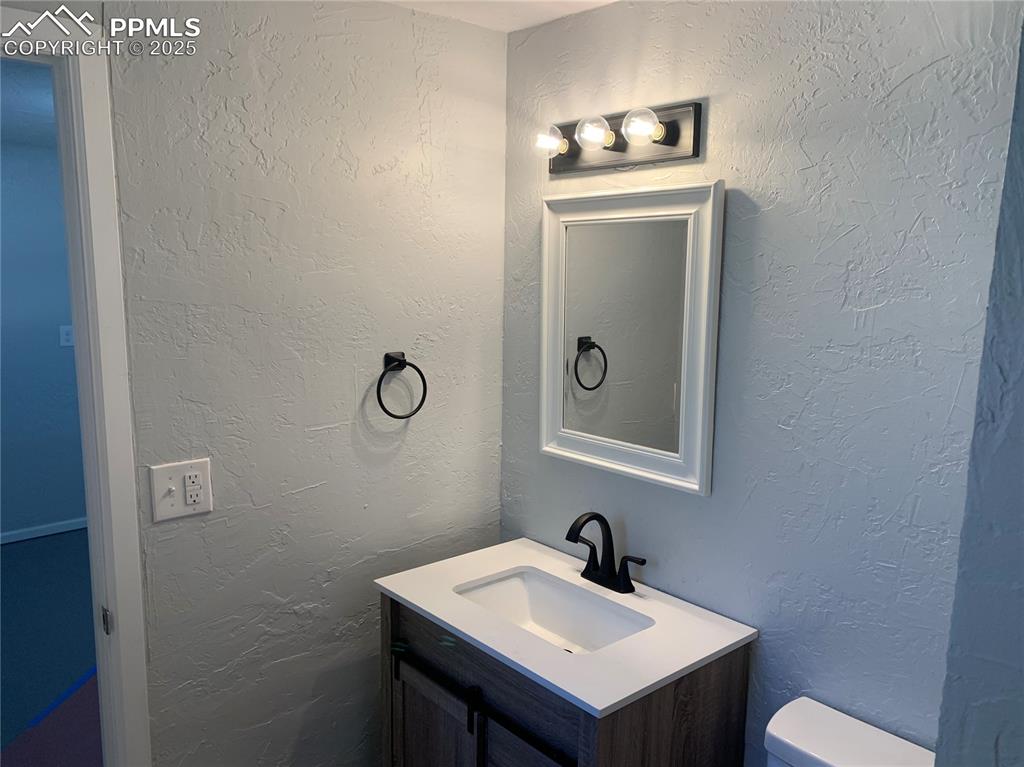 Image 27 of 32: 3/4 bathroom with a textured wall and vanity