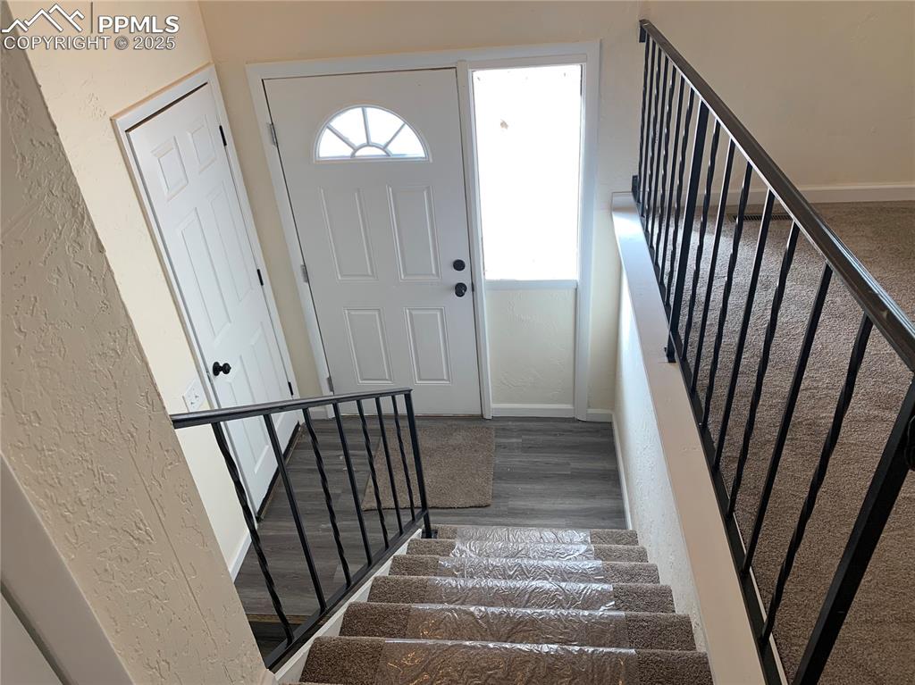 Image 6 of 32: Foyer entrance featuring stairway, a textured wall, plenty of natural light