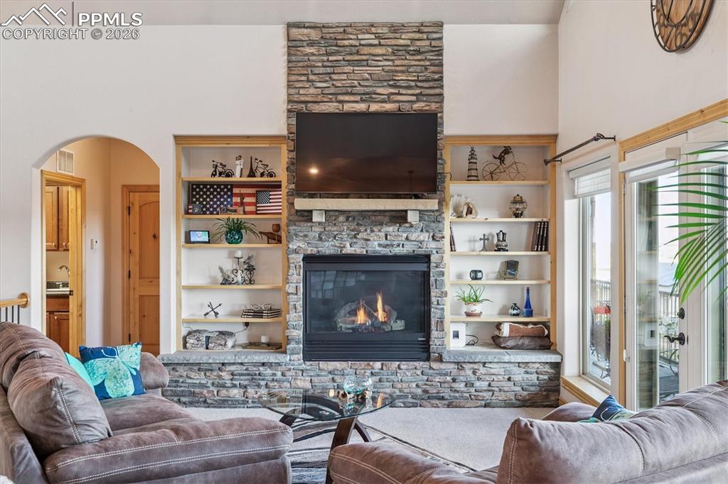 Image 11 of 32: Living room featuring built in shelves, & fireplace