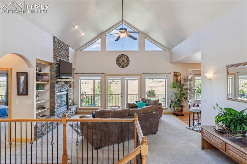 Image 9 of 32: Living area featuring high vaulted ceiling, healthy amount of natural light