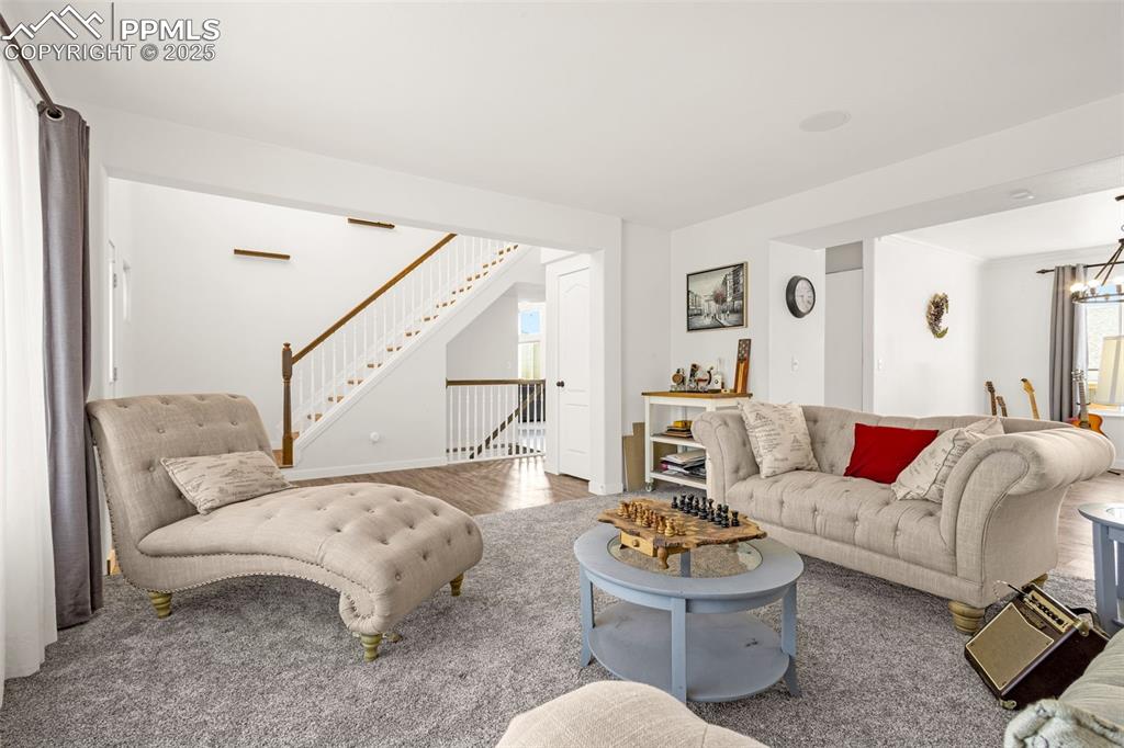 Image 6 of 17: Living room with a notable chandelier and wood finished floors