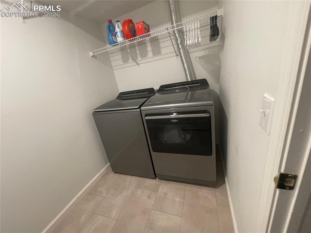Image 15 of 19: Laundry area with separate washer and dryer and light wood finished floors