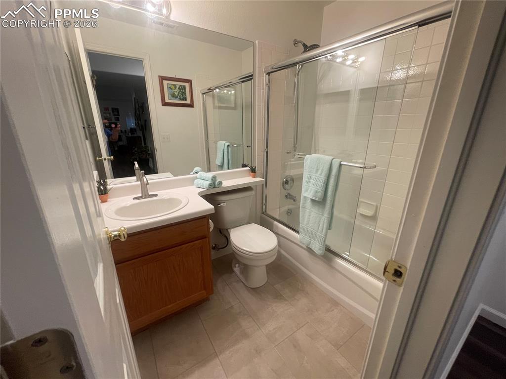 Image 16 of 19: Full bathroom featuring vanity, enclosed tub / shower combo, and light tile