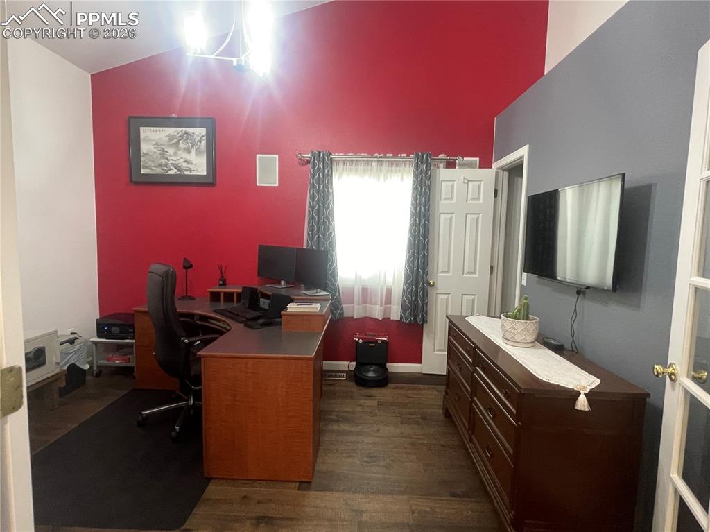 Image 9 of 19: Office area featuring dark wood finished floors and lofted ceiling