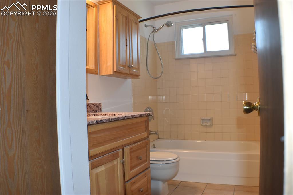 Image 13 of 40: Full bathroom with tile patterned floors, vanity, and shower / tub combinat