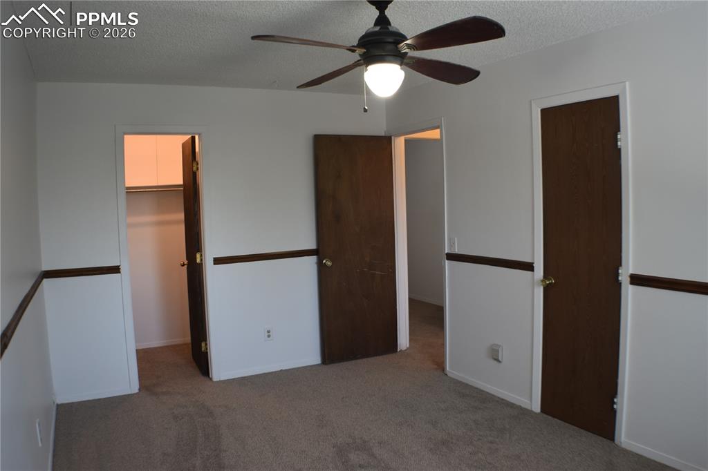 Image 17 of 40: Unfurnished bedroom featuring a spacious closet, carpet floors, a textured 