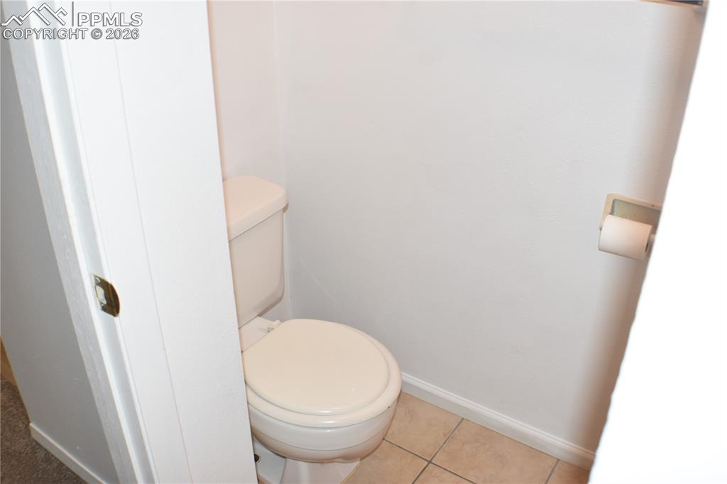 Image 24 of 40: Bathroom with toilet and tile patterned flooring