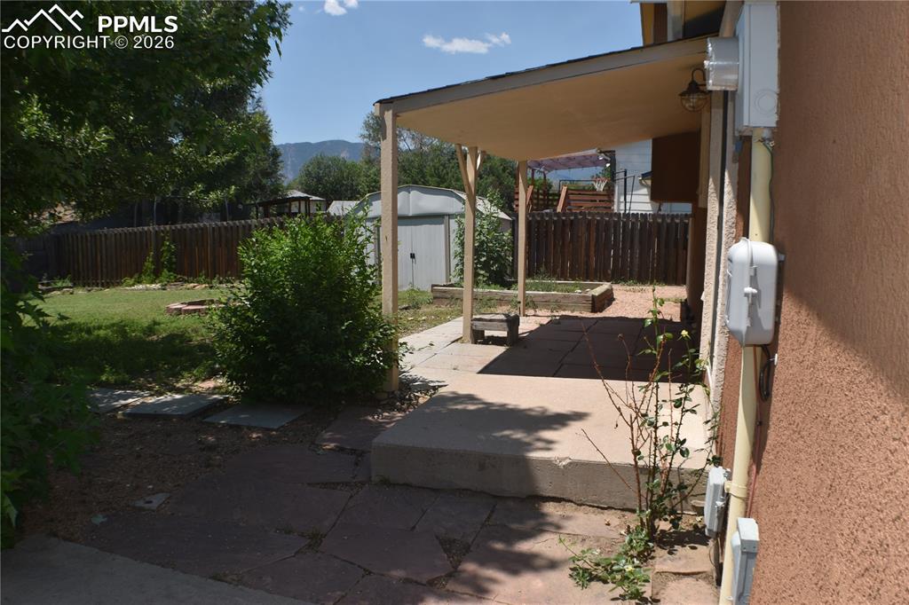 Image 26 of 40: fenced backyard with shed