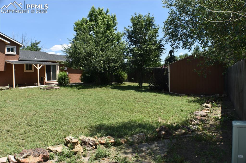 Image 28 of 40: Fenced backyard with a storage shed