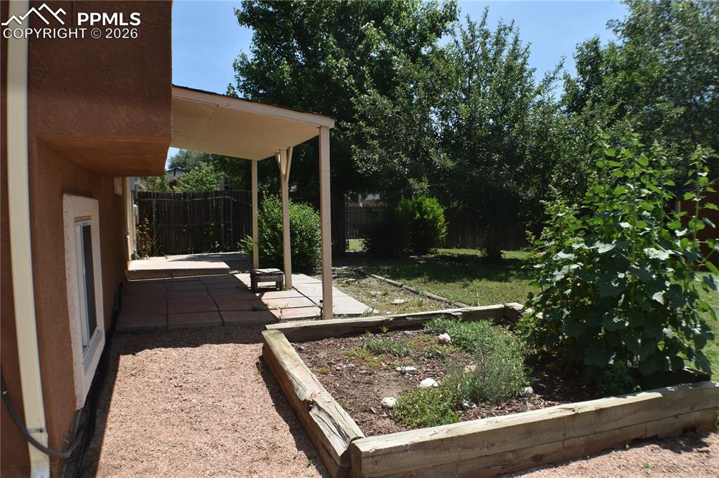 Image 32 of 40: Fenced backyard with a storage unit