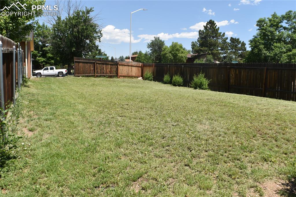 Image 38 of 40: side of additional view of side of fenced backyard that you could add on to