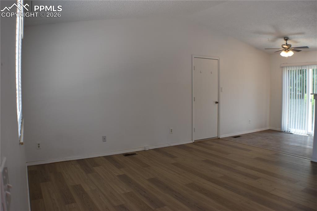 Image 4 of 40: Empty room featuring wood finished floors, ceiling fan, and lofted ceiling