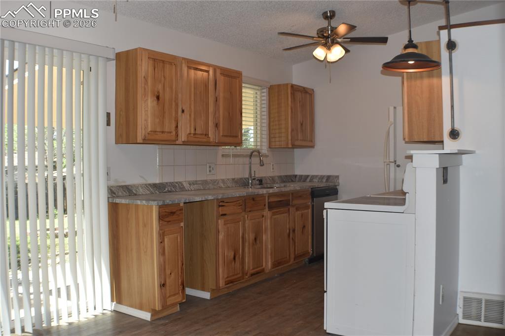 Image 8 of 40: Kitchen featuring a ceiling fan, dishwasher, dark wood-type flooring, taste