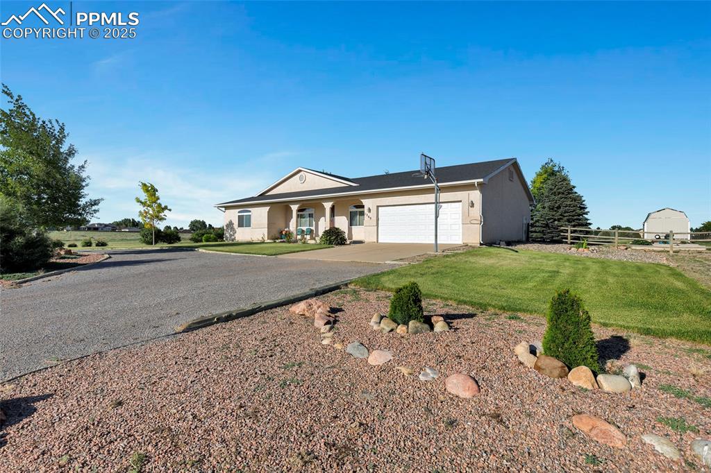 Caption: View of front of property with concrete driveway, a garage, stucco siding, and a porch