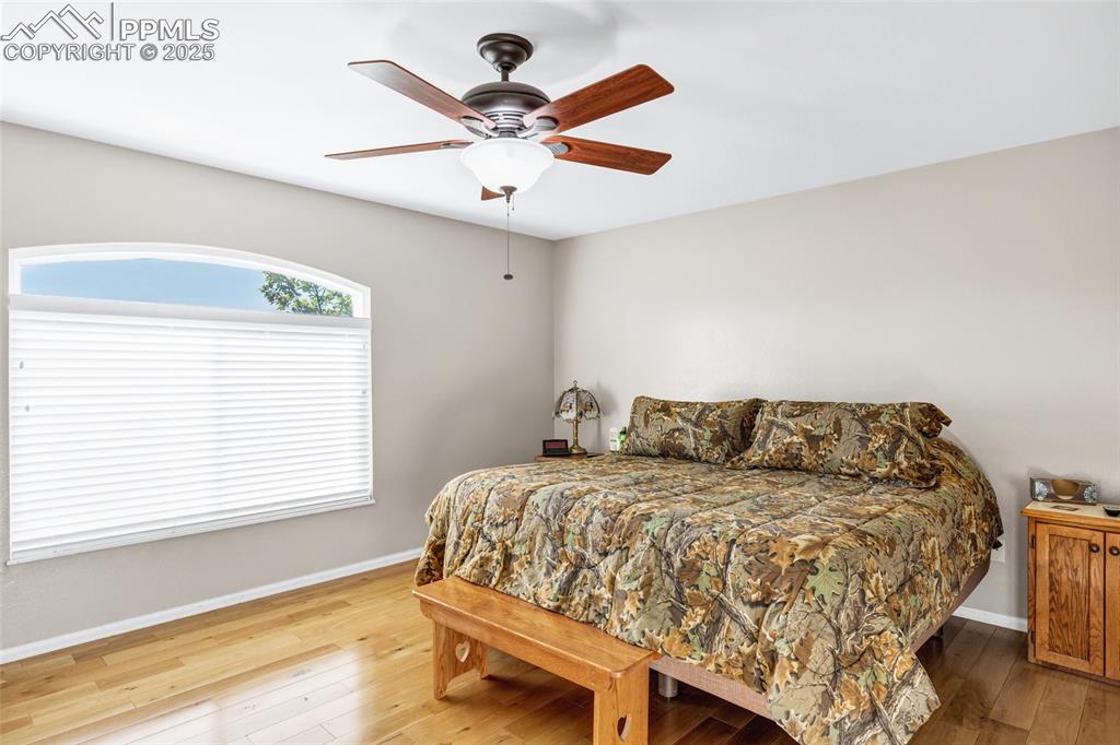 Image 12 of 44: Bedroom with hardwood / wood-style floors and ceiling fan