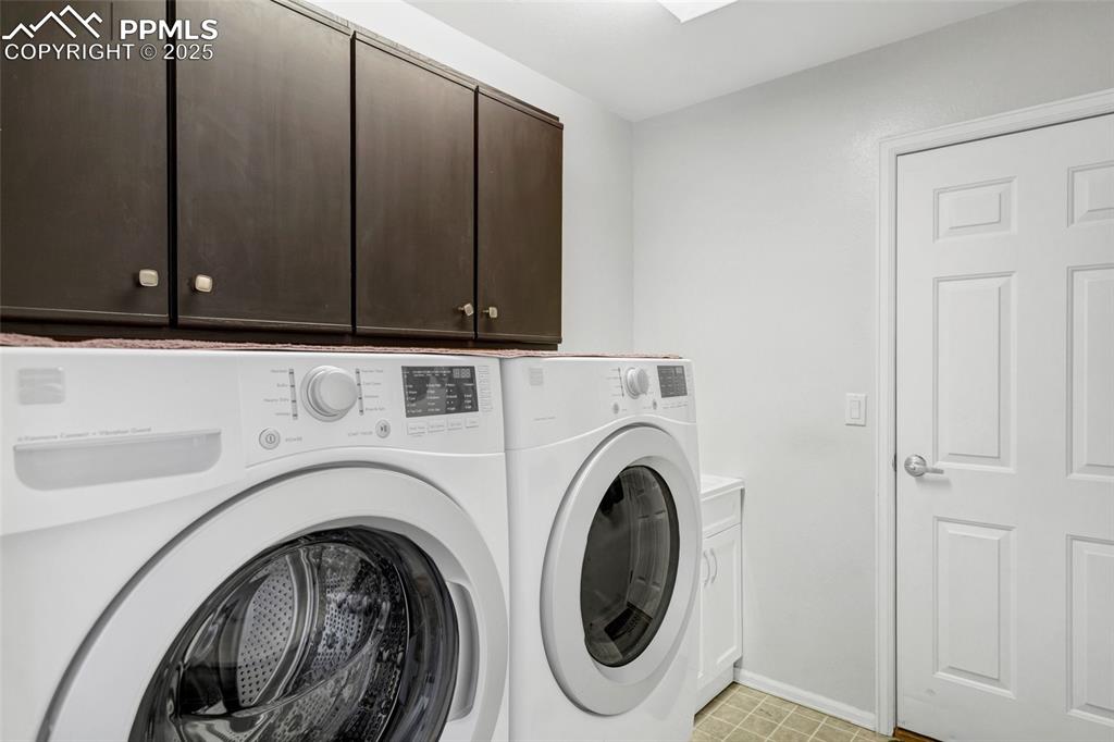 Image 18 of 44: Washroom featuring cabinet space and washer and clothes dryer