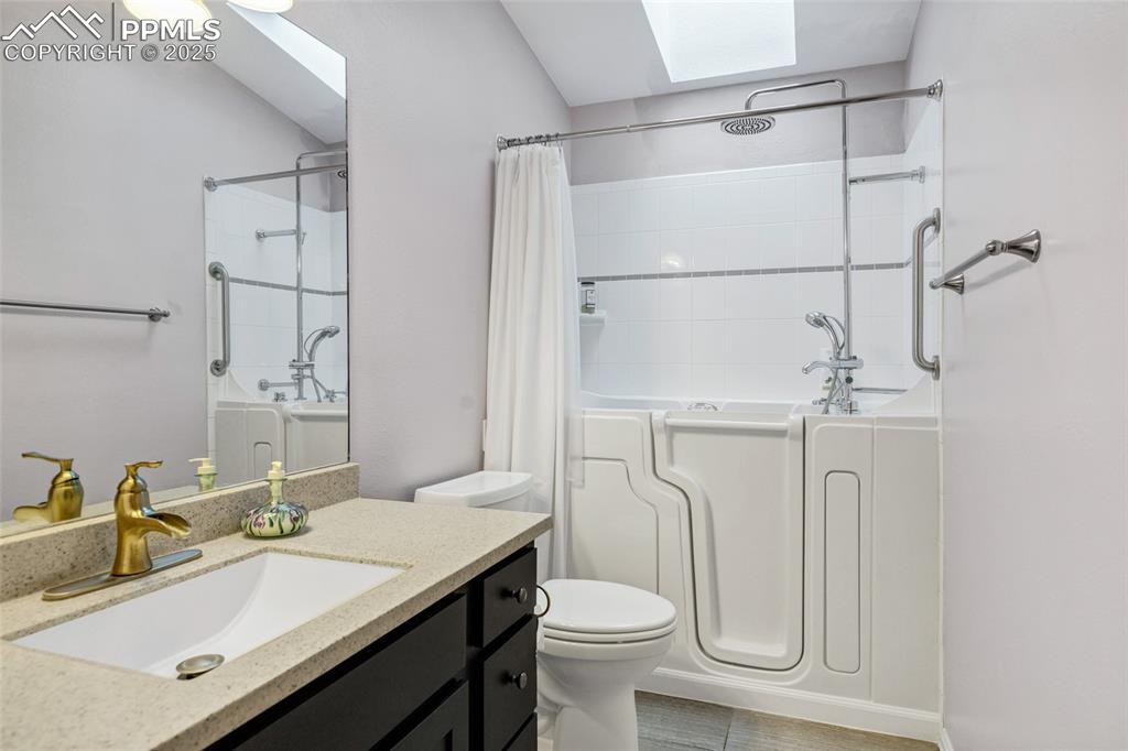 Image 19 of 44: Bathroom featuring a skylight, vanity, and shower / tub combo