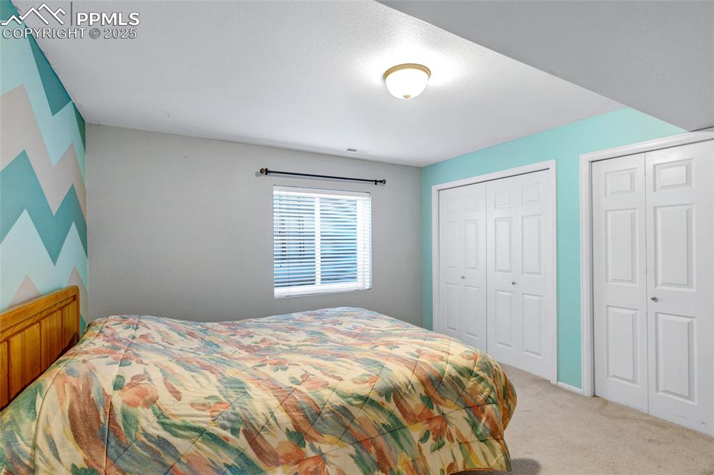 Image 29 of 44: Bedroom with carpet flooring and multiple closets