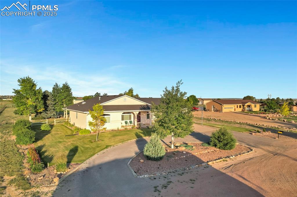 Image 36 of 44: View of front of home featuring a front yard, stucco siding, and driveway