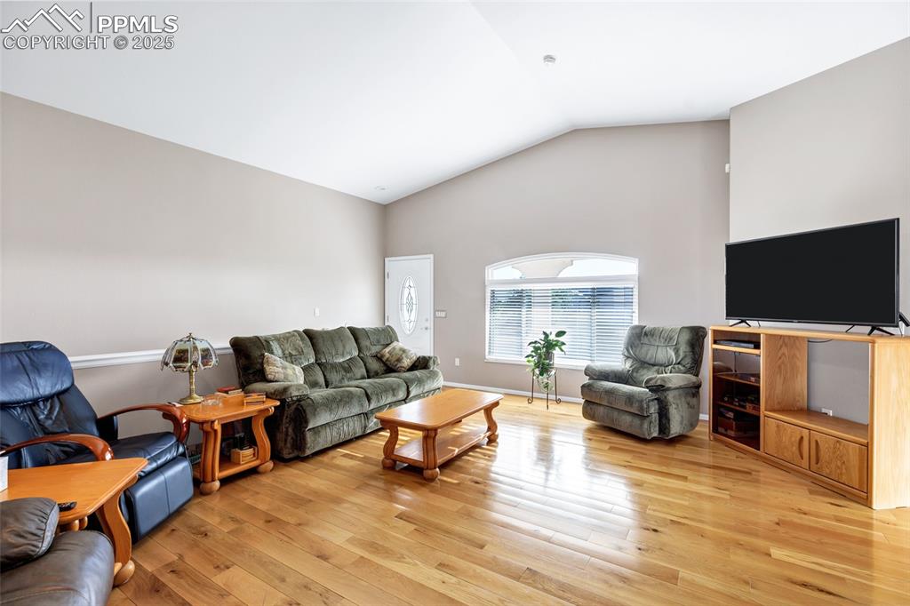 Image 5 of 44: Living room with light wood-type flooring and high vaulted ceiling