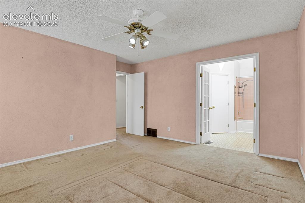 Image 12 of 48: Carpeted interior room with an overhead ceiling fan