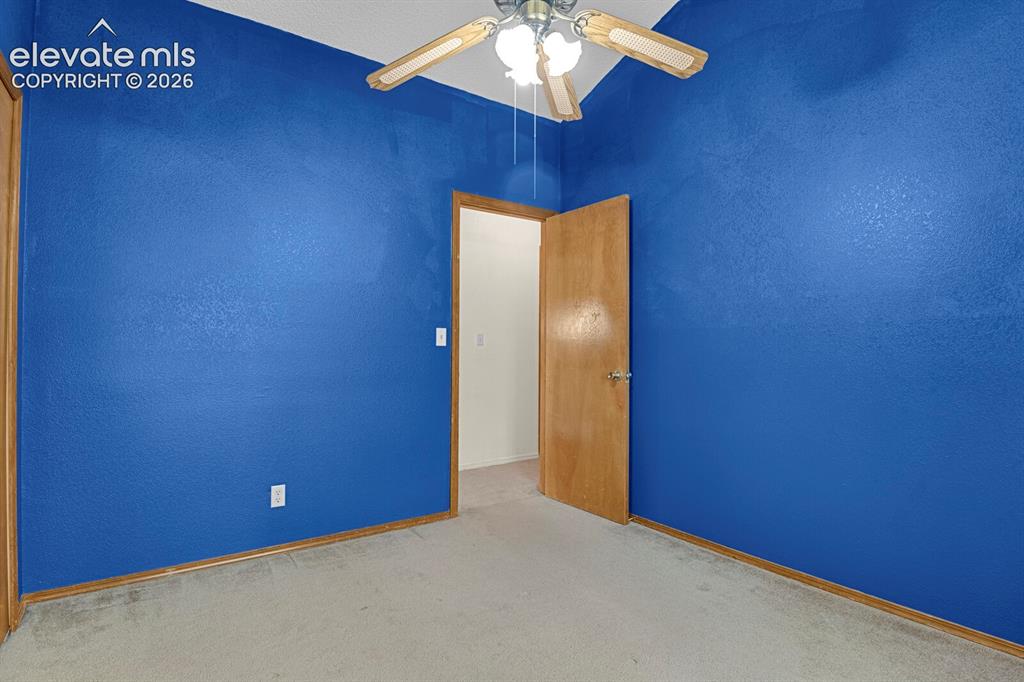Image 15 of 48: Interior room featuring textured blue walls, light-toned carpet flooring, a