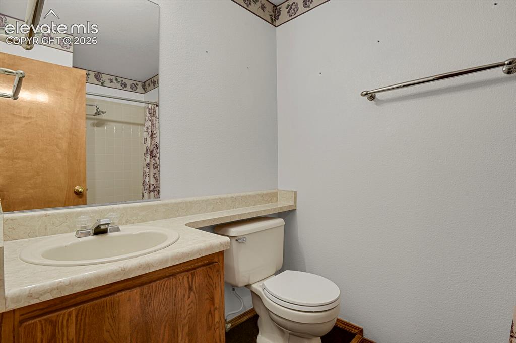 Image 21 of 48: Bathroom featuring a wood-finish vanity with an integrated sink and laminat