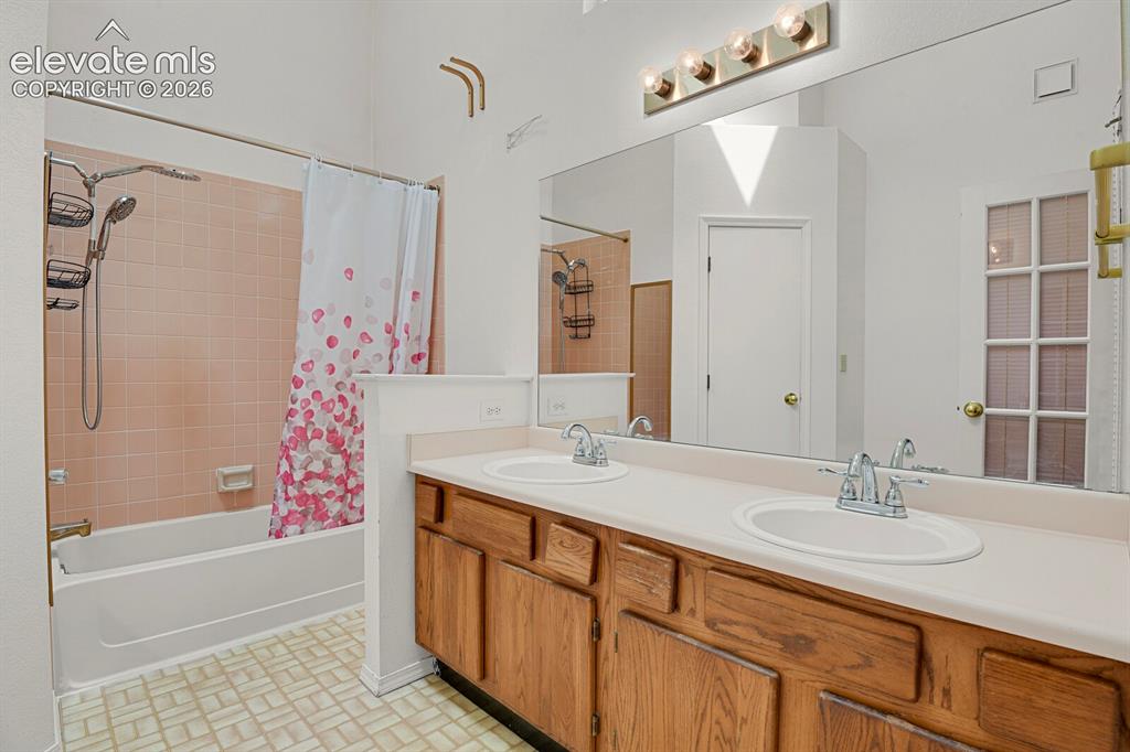 Image 37 of 48: Bathroom featuring a double vanity with two undermount sinks, a full-width 
