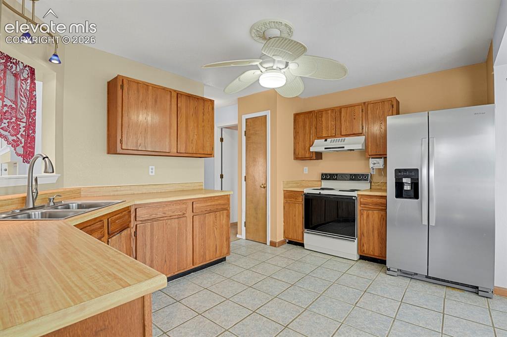 Image 40 of 48: Kitchen featuring wood-finish cabinetry, a stainless steel refrigerator, wh